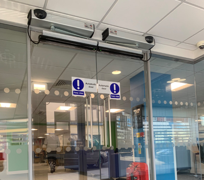 Advanced Glass installing frameless glass automatic swing doors for a modern, accessible entrance solution.