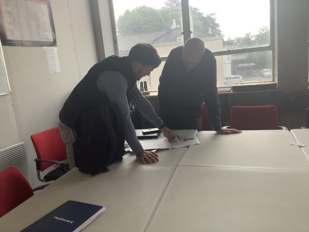 Advanced glass project managers reviewing cladding and facade drawings on site.