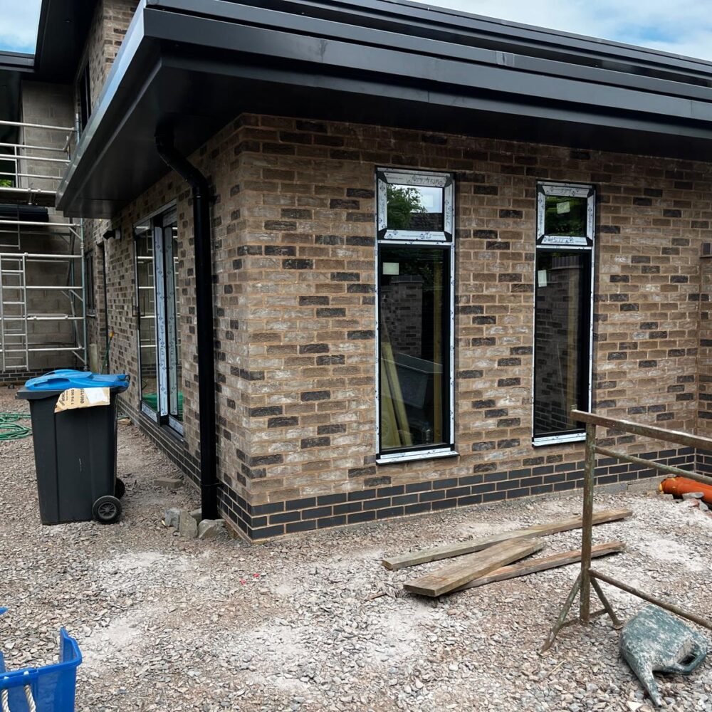 Frameless corner glazing and aluminium windows at Paddock House residential project